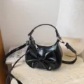Details of the black glossy mini shoulder bag with cute bow, perfect for stylish little girls. - Black