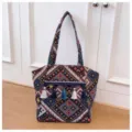Ethnic woven tote bag with colorful geometric patterns and stylish hanging tassels. - Black