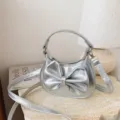 Silver metallic kids handbag with a cute bow, fashionable single shoulder crossbody bag for daily use. - Silver