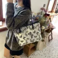 Details of women casual large capacity shoulder tote bag featuring black gold butterfly jacquard. - White