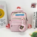 Pink cute cartoon kids backpack detail view with color webbing and cute bear coin pouch. - Pink