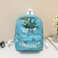 Detailed view of the cute blue kids backpack featuring cartoon print and front pocket design. - Green
