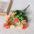 Gedetailleerd overzicht van kunstmatige anjerbloemen, prachtig oranje en crème bloemstuk voor decoratie. - Zonsondergangrood