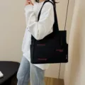Black canvas tote bag for women, large capacity shoulder book bag with literary design. - Black