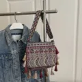 Bohemian ethnic style woven crossbody bag with colorful geometric patterns and chic tassels. - Red