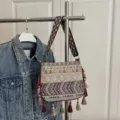 Bohemian ethnic style woven shoulder bag with colorful geometric strap and tassel charms. - Yellow