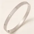 Eleganter Edelstahl Kleeblatt Armreif mit gestreifter Textur und funkelnden Steinen. - Gestreifter Kleeblatt Strass Stil / Stahlfarben