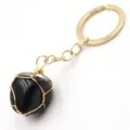 Detail shot of a handmade wire-wrapped black stone keychain pendant with gold keyring hardware. - 3-Section Chain / Black Agate