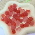 Detailaufnahme von rohen Kristallsplittersteinen in einer Sternschale, ideal für DIY Schmuck. - Wassermelonenrot