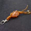 Natural crystal rough stone keychain detail featuring woven mesh wrap and secure metal clasp. - Rose Quartz