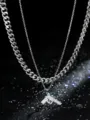 Close-up van de strass-pistoolhanger en de dubbellaagse zilveren roestvrijstalen ketting. - Staalkleur