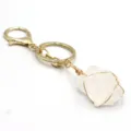 Primer plano del llavero de piedra de cristal blanco bruto con mosqueton dorado hecho mano. - Cuarzo blanco envuelto en alambre dorado