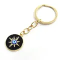 Porte-clés en alliage doré avec détail d'étoile noire et pendentif mauvais œil. - Porte-clés soleil