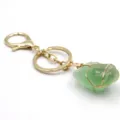Vista detallada del llavero de piedra bruta de cristal verde hecho a mano con alambre. - Fluorita verde envuelta en alambre dorado