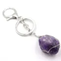 Detailaufnahme eines rohen Amethyst Kristall Draht gewickelten Schlüsselanhängers, Silber Metall. - Mit Silberdraht umwickelter Amethyst