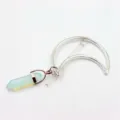 Detail shot of the crescent moon hair clip with a light blue hexagonal crystal pendant. - Opal