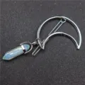 Gedetailleerde close-up van een elegante halve maan haarklem met een zeshoekige kristallen hanger. - Haarclip & opaal