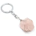 Portachiavi in cristallo di quarzo rosa grezzo avvolto in filo metallico dettaglio primo piano. - Quarzo rosa avvolto in filo d'argento