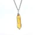 Close-up detail of yellow crystal bullet pendant with silver wire wrap and chain necklace. - Silver Wire Wrapped Pendant / Transparent Yellow