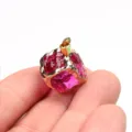 Close-up detail shot of the gold-edged magenta crystal cube pendant, perfect for DIY jewelry making. - Purple