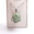 Close-up detail of natural green crystal stone metal cage pendant necklace with adjustable chain. - Silver Mesh Bag with Stone / Green Aventurine