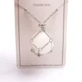 Close-up detail of the natural crystal metal mesh cage pendant necklace with adjustable chain. - Silver Mesh Bag with Stone / White Crystal