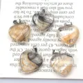 Detailansicht natürlicher Kristall-Herzanhänger mit Metallösen und Edelsteinstruktur. - Transparent Schwarz & Gelb