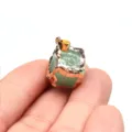 Nahaufnahme des grünen Kristallwürfel-Anhängers mit wunderschönen metallisch goldenen Kanten. - Dunkelgrün