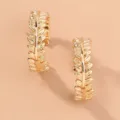 Detailed view of gold C-shaped leaf hoop earrings, featuring delicate metallic texture. - NE776-C-Shaped Alloy Leaf Earrings