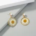 Closeup detail of gold-plated earrings featuring clear resin pressed daisy and pearl stud. - NE830 - Gold White Chrysanthemum Single Loop White Button Pearl Earrings