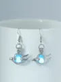 Detailaufnahme leuchtender hohler Vogelohrringe mit blauer Perle und silbernem Haken. - NY1001 Meeresschnecke + Himmelblau Leuchtend