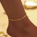 Nahaufnahme Detailaufnahme der glitzernden Gold-Fußkette am Fußgelenk mit feiner Textur. - Goldenes Sternenlicht Fußkettchen (2468金色)