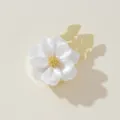 Close-up detail of white floral button cover featuring shiny gold tone metal base. - Cream