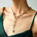 Primo piano dettagliato della elegante collana a clavicola con mezza perla e catena dorata. - Giunzione di Perle (NZ1473)