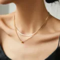 Primo piano di una collana a doppio strato minimalista con catena a serpente e perla. - Perle di Rame (NZ1474)