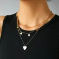 Collana girocollo multistrato dorata con ciondolo a cuore e dischetti delicati. - Paillette a Cuore (NZ1471)