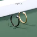 Close-up detailopname van U-vormige neusringen in zwart en goud met mooie kristallen versieringen. - Zwart en Goud