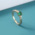 Prachtige detailopname van een gouden ring met groene edelsteen en fijne zirkonia's. - Groen(SE1511)