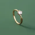 Gedetailleerde close-up van een chique vergulde getwiste ring met heldere zirkonia steen. - Transparant(SE1515)