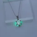 Nahaufnahme einer leuchtenden Schildkröten-Halskette mit grünem Effekt im Detail. - Gelb-Grünes Leuchten / Silber (NY729)
