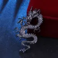 Primer plano de un broche de dragon chino de metal negro vintage, diseno retro de hombre. - Negro
