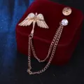 Detailopname van de prachtige engelenvleugel broche met strass steentjes en dubbele kettingen. - Goud met kleine strass-steentjes