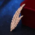 Golden feather brooch detail close up, vintage leaf lapel pin, elegant suit corsage accent. - Gold