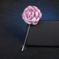Vue détaillée de l'élégante épingle de revers en tissu rose camélia avec longue tige. - Violet