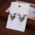 Vintage bronze deer head brooch collar pin retro style accessory on white display card. - Deer Head Lapel Pins Pair / Bronze