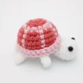 Makroansicht der filigranen Textur einer niedlichen handgefertigten Häkelschildkröte - 8.5cm / Puppen-Stil / Rosa