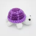 Detaillierte Nahaufnahme der handgemachten Häkel-Schildkröte mit lila Wollpanzer - 8.5cm / Puppen-Stil / Lila