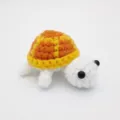 Makro-Detail einer handgehäkelten Schildkröte aus Garn mit feiner Textur und Design. - 7cm / Puppen-Stil / Gelb