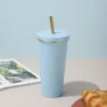 Light blue stainless steel tumbler with golden straw in a variant showcase. - Blue [Gold Trim]