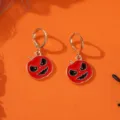 Nahaufnahme von Halloween Kürbis Ohrringen, rotes Emaille Kürbis Detail auf orangem Grund. - Ein Paar Kürbisse mit Fratzengesicht